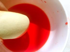 取一个烧果子在里面滚一下，让烧果子全部沾满橘红色，之后放一旁晾干