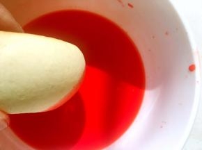 取一个烧果子在里面滚一下，让烧果子全部沾满橘红色，之后放一旁晾干