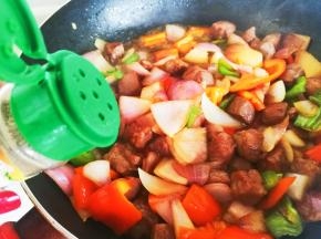 加入黑胡椒粉，翻炒至牛排丁八成熟