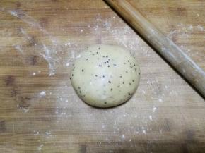 松弛两小时后取出面团，放在大的面板上，面板撒适量面粉防粘，然后用擀面杖将面团慢慢推开推大