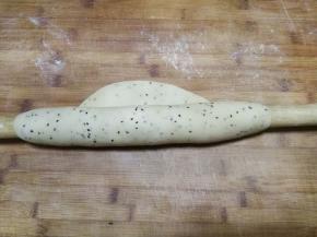 然后用擀面杖从一端卷起，开始擀面，擀面期间要不时地展开掉转方向擀，使面团越来越薄、越来越大，同时记得展开后在面团表面撒粉防粘，然后继续擀面