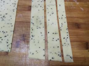 将圆形面片折叠后，借助擀面杖或长直尺切出长条形，分别切出2指宽、3指宽、4指宽的长条