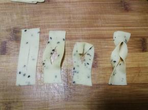 2指宽的长条再切成约5cm长的小段，用刀从中间切一下，然后如图将上部面片从中间的切口穿进去再拉出，2指宽的麻叶整形就做好了