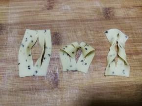 与2指宽的麻叶整形方法一样，切3刀后的面片展开后，上部从中间的切口穿进去再拉出来，一个3指宽的麻叶整形做好了