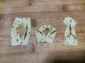 与2指宽的麻叶整形方法一样，切3刀后的面片展开后，上部从中间的切口穿进去再拉出来，一个3指宽的麻叶整形做好了