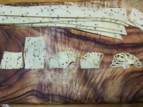 这是4指宽面片做成扇形的整形方法，把4指宽面片对折后切成10～12股，展开后左上角对右下角按紧，然后右上角也慢慢收拢与右下角右侧部分重合按紧，最后左下角也慢慢收拢与右下角左侧部分重合按紧，稍微整理一下就成为扇子一样了