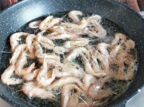 起油锅，油温6成时加入拌好生粉的河虾。