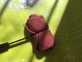 卷好后，用刀沿着筷子压出的痕迹，从中间切开，玫瑰花就做好啦，底下撒点干粉，放一旁备用