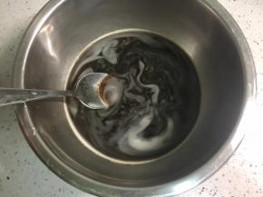 把红糖倒入温水，用勺子搅拌至融化。