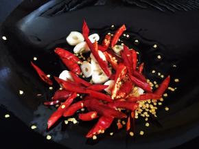 锅内放油烧热，放入大蒜片和干红辣椒段爆香