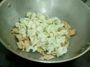 倒入花菜，再加入少许盐，快速翻炒片刻后出锅。