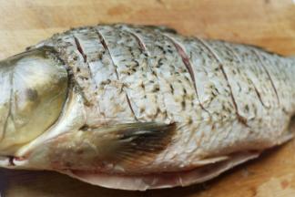 鲤鱼一条，不要选太大的，太大了锅装不下。我这条是1.8斤重，买的时候让摊主收拾干净。做的时候清洗一下，去掉鱼身两边的腥线，然后打花刀，花刀要打的深一点，炸出来才会明显，我这个还是不够深。