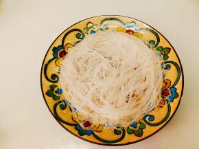 粉丝用剪刀剪成几段，平铺在盘底,