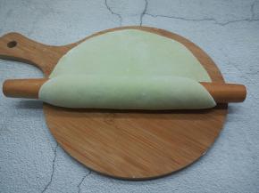 醒发好的面团分成3个，取其中一个放案板，用擀面杖擀成大面片，