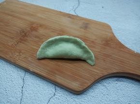 拿一张饺子皮，放牛肉馅，对折捏紧