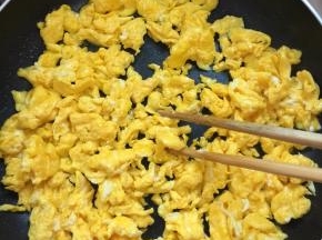 锅烧热倒入适量的油，把蛋液倒入锅中，用筷子快速把蛋液划散，成均匀的鸡蛋粒儿。