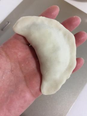 把面皮对折，边缘处捏紧。