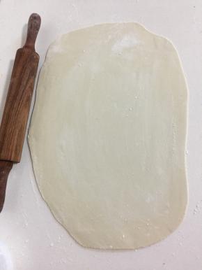 醒好的面团充的排气揉匀，用擀面杖擀成硬币厚的薄片。（也可以搓成长条状，分成若干小挤子再擀成小圆片，总之你觉得怎么顺手怎么简单怎么来操作就可以啦！）