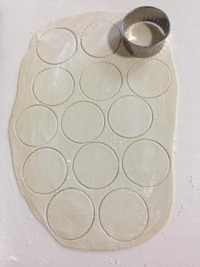 面片上撒少许面粉，用大饺子皮模具按压成小圆片。