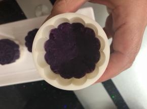 月饼模具刷一点油，一半先用紫薯填上压紧。