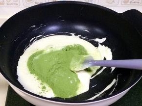 迅速加入之前过筛好的抹茶粉和奶粉，用刮刀继续搅拌煮至无干粉状态。
