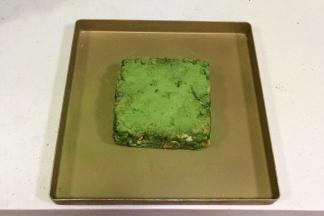 给整形好的雪花酥筛上混合好的2克抹茶粉和10克奶粉。（在食谱份额外的）