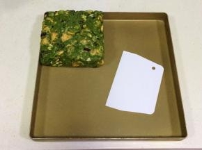 带上一次性手套慢慢推压紧实雪花酥团，然后进一步借用塑料刮板整形成方形。