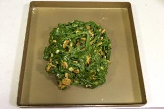 把雪花酥团倒入不粘烤盘内，用双手不停往外翻，直到饼干和坚果料都被千丝万缕的糖包裹住。