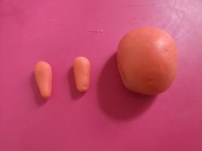 滚圆后，将小面团分成2份，搓成长条形做小兔的耳朵。