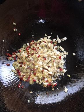 锅中留适量的底油，放入蒜瓣，生姜，花椒，干辣椒，泡椒炒出香味儿。