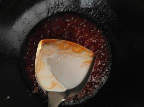 9、白糖熔化后，加入水淀粉，用锅铲顺时针方向搅拌均匀。