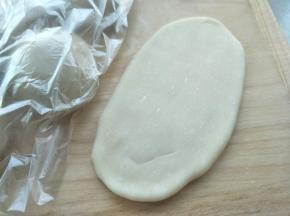 这个时候可以处理包好油酥的面团了。首先擀开成牛舌状。