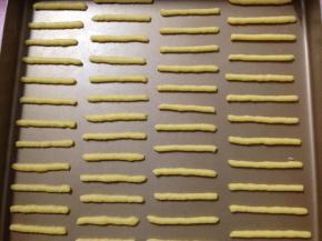 在不沾烤盘中挤出约5-6cm的长条，烤箱170度预热（我的这个量28x28cm烤盘正好两盘）