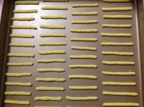 在不沾烤盘中挤出约5-6cm的长条，烤箱170度预热（我的这个量28x28cm烤盘正好两盘）