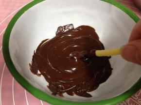 冷却好的饼干顶部逐个沾上巧克力