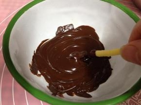 冷却好的饼干顶部逐个沾上巧克力
