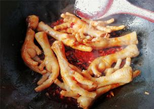 把调制好料汁倒入翻炒，让鸡爪混合均匀