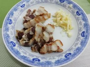 腊肉焯水，然后切成薄片，蒜切成粒