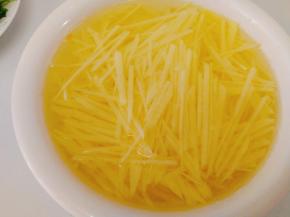 再将土豆片切成细丝，将切好的土豆丝泡去淀粉，（这样炒出的土豆丝清爽不粘）。