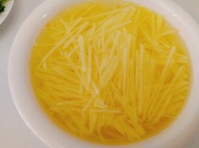 再将土豆片切成细丝，将切好的土豆丝泡去淀粉，（这样炒出的土豆丝清爽不粘）。