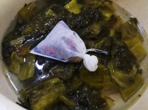 把酸菜挖到锅里，加入之前装入煲汤袋里面的调料，加适量的水，大火烧开，小火闷十分钟左右
