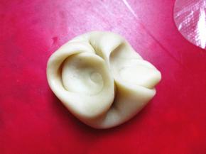 取一个面剂子，两侧向中间用手指压扁，擀成圆饼