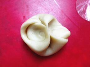 取一个面剂子，两侧向中间用手指压扁，擀成圆饼