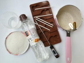 准备熬糖的工具和材料，工具有：不沾小奶锅、温度计、如意坊棒棒糖模具和棒棒糖纸棒