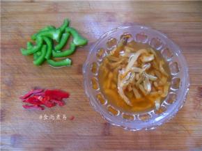 榨菜丝浸泡片刻，捞起挤干水分、去除部分盐分、辣椒洗净切丝