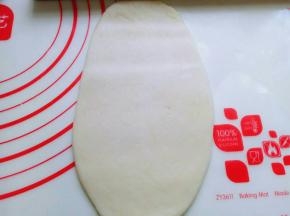 取一面团，用掌心轻轻按压，再用擀面杖来回擀长舌状。