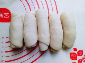 全部做好后用保鲜膜盖上，松弛15分钟，之后再取一块面团，面团竖着用擀面杖来回擀的长舌状，这样反复两次。就是:擀长舌状再卷起来，再擀长舌状，卷起来，同样操作方法。