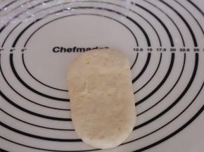 松弛好的面团再次排气，擀成长舌形