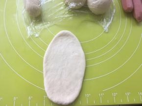 取一份松弛好的面团，擀成长条，松弛好的面团擀起来会有轻微回缩，回缩过大，证明你的面团没松弛好，可以再静至一会