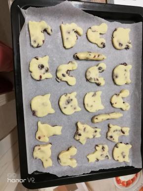 用饼干模具压出饼干胚，放在烤盘上，多余的边角料整形后再压出饼干胚